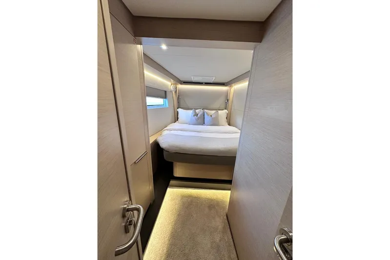  Yacht Photos Pics Luxurious cabin interior of 2021 Lagoon 50 yacht with cozy bed and modern lighting.