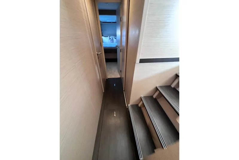 Yacht Photos Pics Interior hallway of 2021 Lagoon 50 yacht, featuring modern design and wooden stairs.