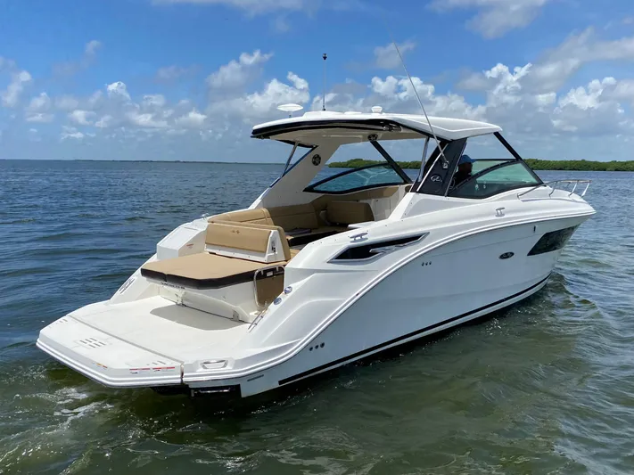 2023 Sea Ray Sundancer 320 @ Imp Def Yacht Photos Pics 2023 Sea Ray Sundancer 320 cruising on open water under a clear blue sky.
