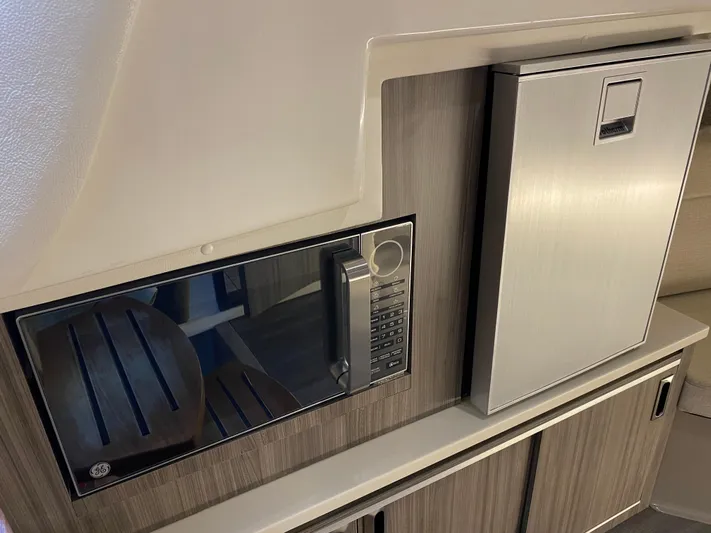 2023 Sea Ray Sundancer 320 @ Imp Def Yacht Photos Pics 2023 Sea Ray Sundancer 320 interior with microwave and compact refrigerator.