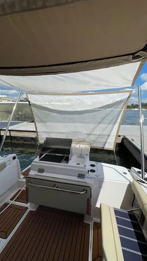  Yacht Photos Pics 2026 Ranger Tugs R-27 boat with outdoor grill and seating, docked by the water.