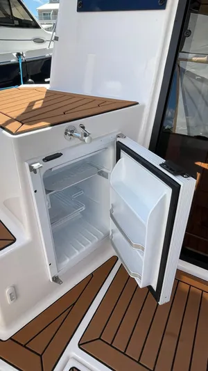  Yacht Photos Pics Open fridge on 2026 Ranger Tugs R-27 boat, showcasing teak deck and modern design.