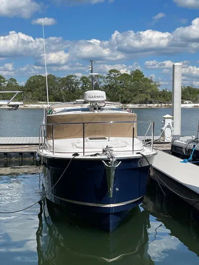  Yacht Photos Pics 2026 Ranger Tugs R-27 boat docked, featuring Garmin equipment, under a partly cloudy sky.