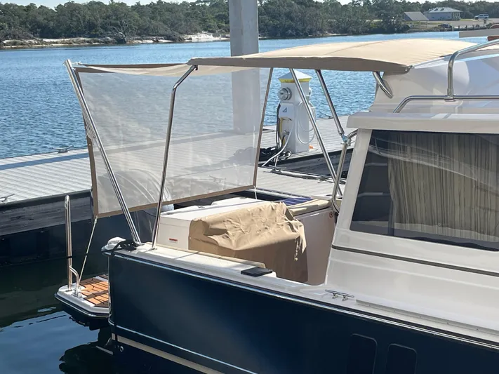  Yacht Photos Pics 2026 Ranger Tugs R-27 docked, featuring a covered deck and scenic waterfront view.
