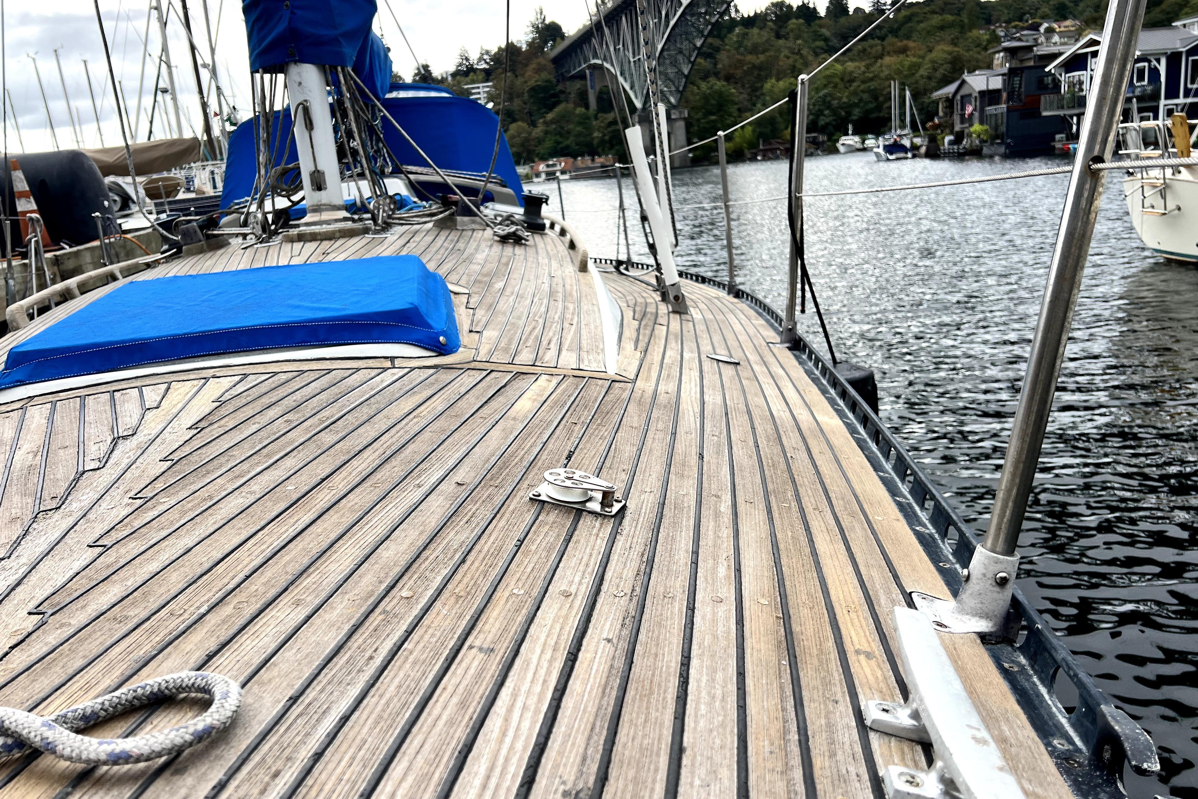 1983 CT 38 Warwick sailboat deck with blue cover, docked by a scenic waterfront.