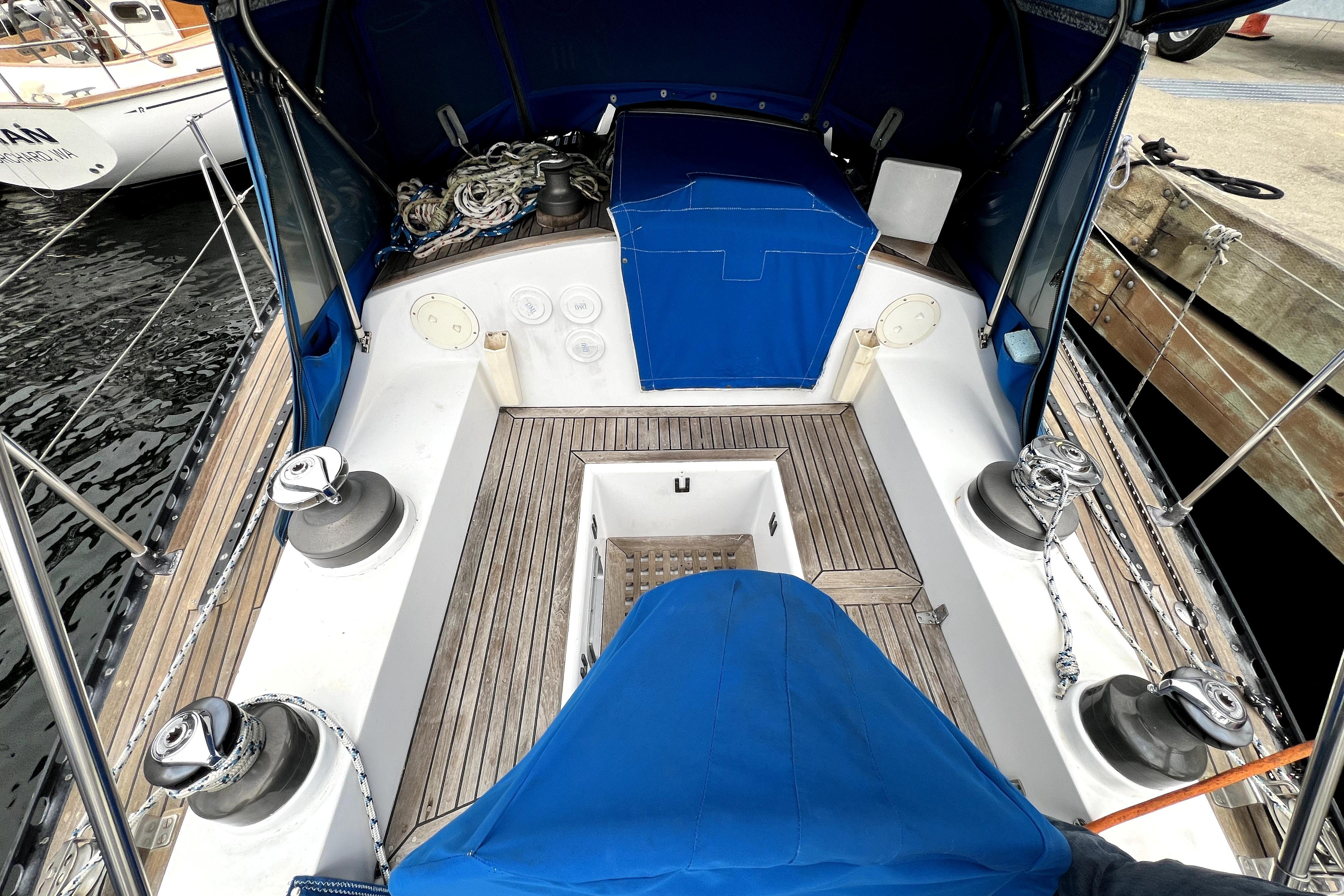 Cockpit of 1983 CT 38 Warwick sailboat with blue canopy and wooden deck.