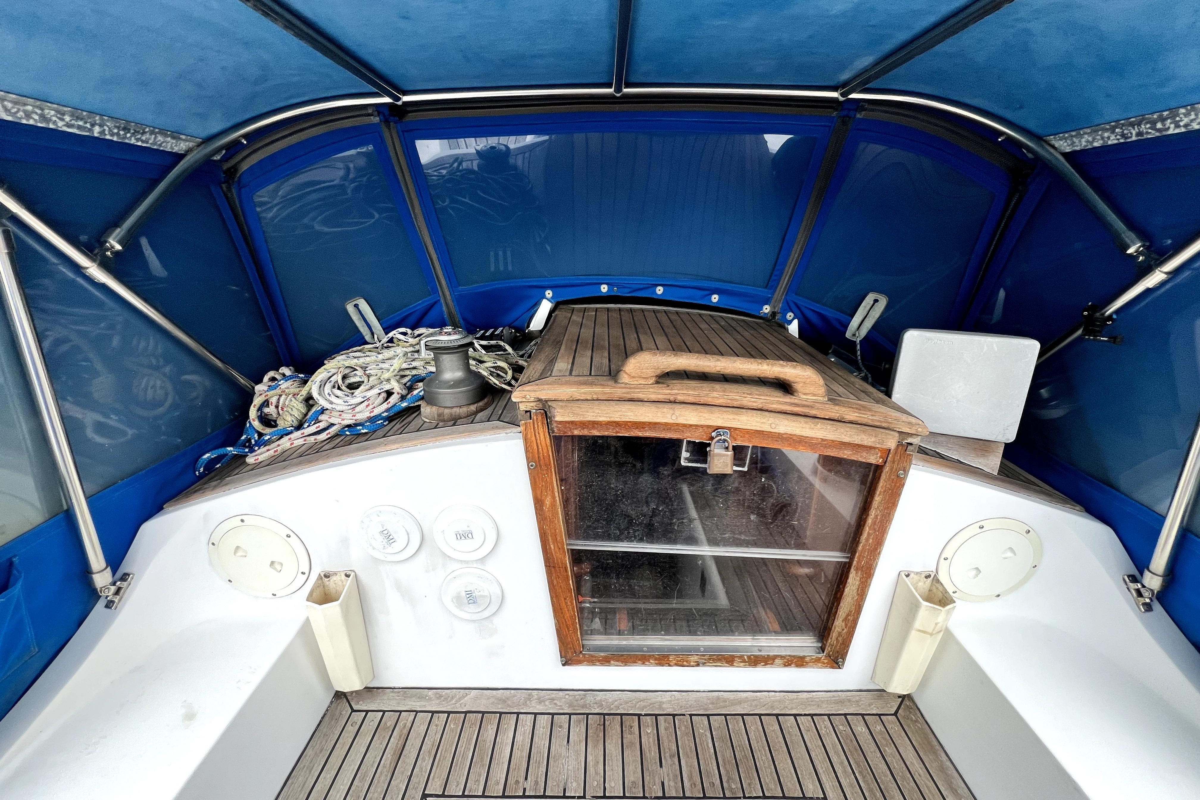 1983 CT 38 Warwick boat cockpit with blue canopy and wooden hatch.