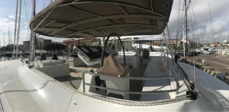 Sunset O Yacht Photos Pics 2019 Lagoon 620 yacht docked at marina, featuring spacious deck and helm.