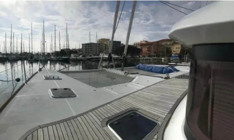 Sunset O Yacht Photos Pics 2019 Lagoon 620 yacht docked in marina, showcasing sleek deck and modern design.