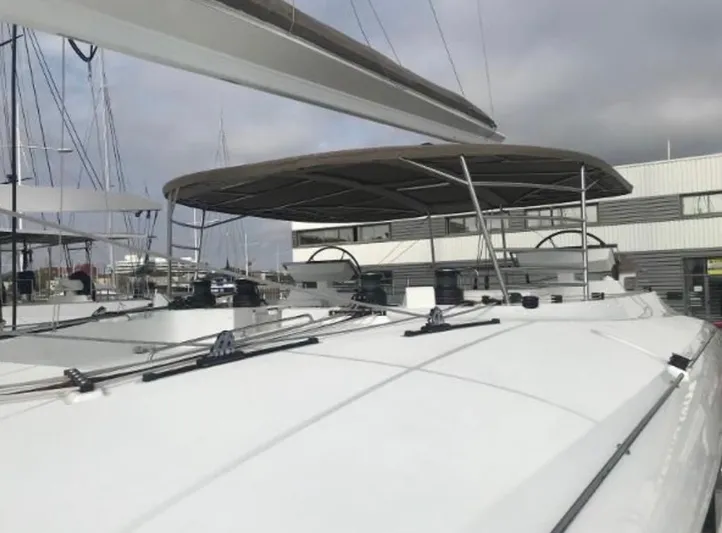 Sunset O Yacht Photos Pics 2019 Lagoon 620 catamaran with sleek design, docked at a marina under cloudy skies.