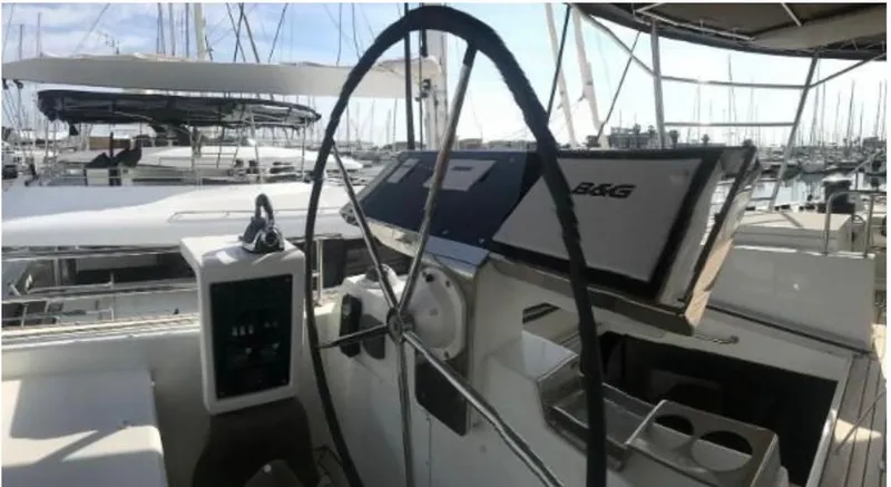 Sunset O Yacht Photos Pics Helm of 2019 Lagoon 620 catamaran with navigation equipment in a marina setting.