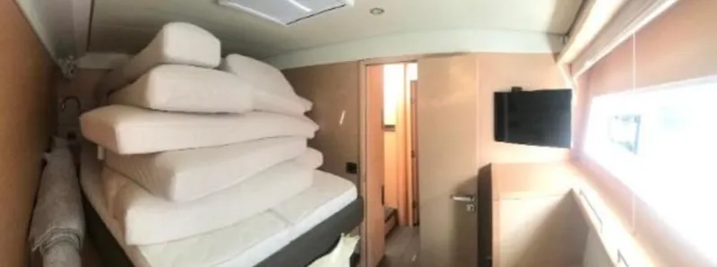 Sunset O Yacht Photos Pics Interior of 2019 Lagoon 620 yacht cabin with stacked mattresses and wall-mounted TV.