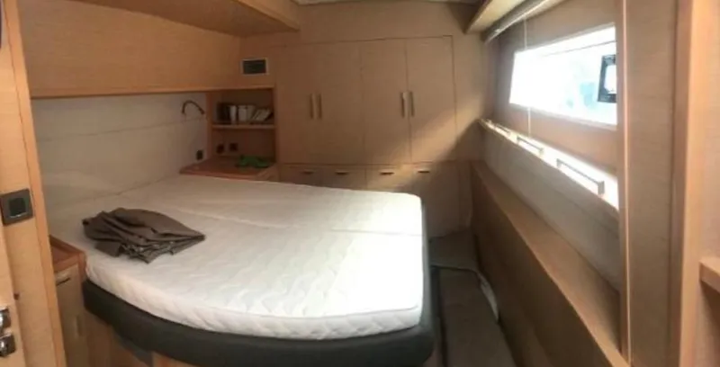 Sunset O Yacht Photos Pics Luxurious cabin interior of 2019 Lagoon 620 yacht with bed and storage.