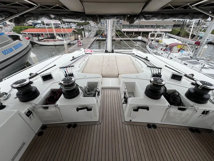 Sunset O Yacht Photos Pics Luxurious 2019 Lagoon 620 yacht deck with winches and seating, docked at a marina.