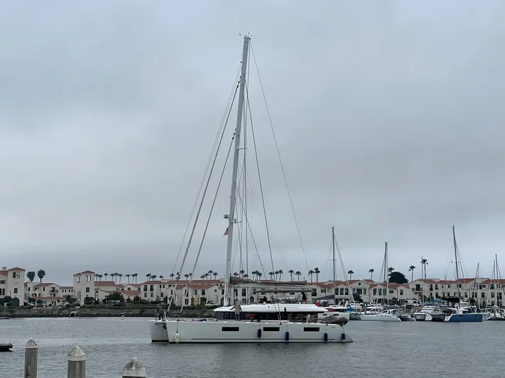 Sunset O Yacht Photos Pics 2019 Lagoon 620 catamaran docked in a marina with overcast skies.