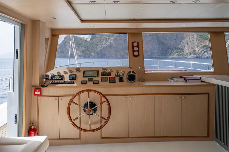  Yacht Photos Pics Pilothouse of 2024 Custom 27m Trawler with wooden helm and navigation instruments.