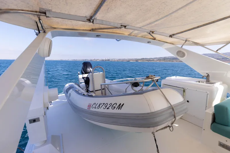 3ten Yacht Photos Pics 1997 West Bay Sonship yacht with dinghy on deck, overlooking serene ocean view.