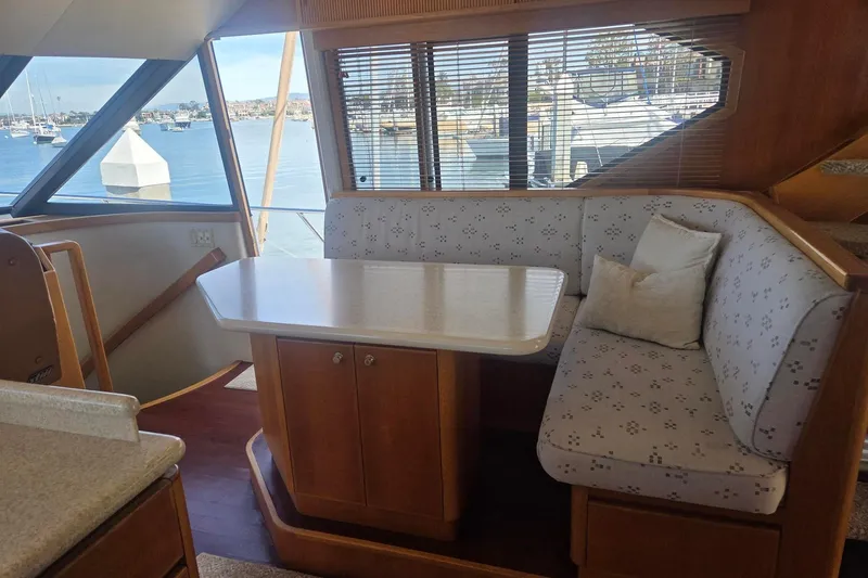 3ten Yacht Photos Pics 1997 West Bay Sonship yacht interior with dining area, featuring cushioned seating and waterfront view.