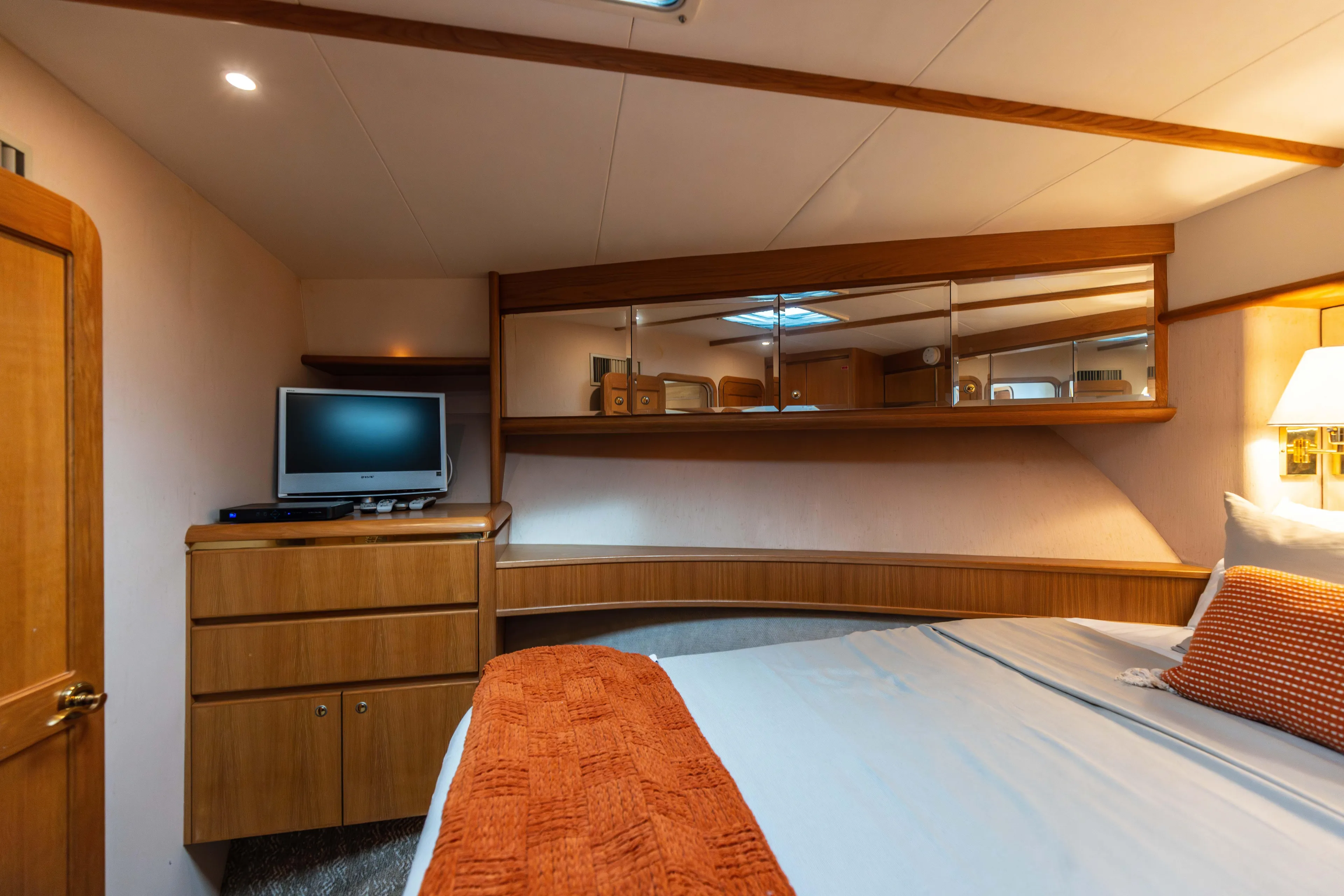 3ten Yacht Photos Pics Luxurious 1997 West Bay Sonship yacht bedroom with TV, wooden cabinetry, and cozy bedding.