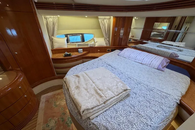  Yacht Photos Pics Luxurious bedroom interior of 2007 Azimut 68 EVO yacht with elegant wood finishes.