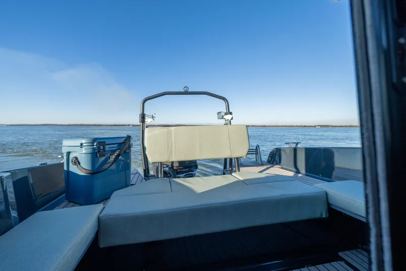  Yacht Photos Pics Arksen 28 boat 2025 model with seating and cooler on a calm lake.