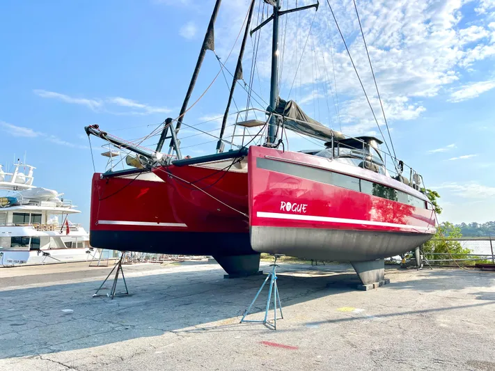 Rogue Yacht Photos Pics Red Privilege 510 catamaran on land, 2021 model, under clear blue sky.
