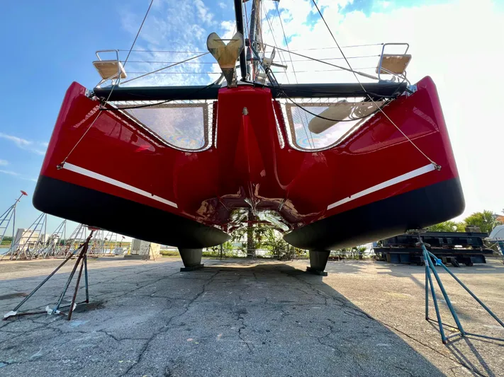 Rogue Yacht Photos Pics Red Privilege 510 catamaran from 2021 on dry dock, viewed from below.