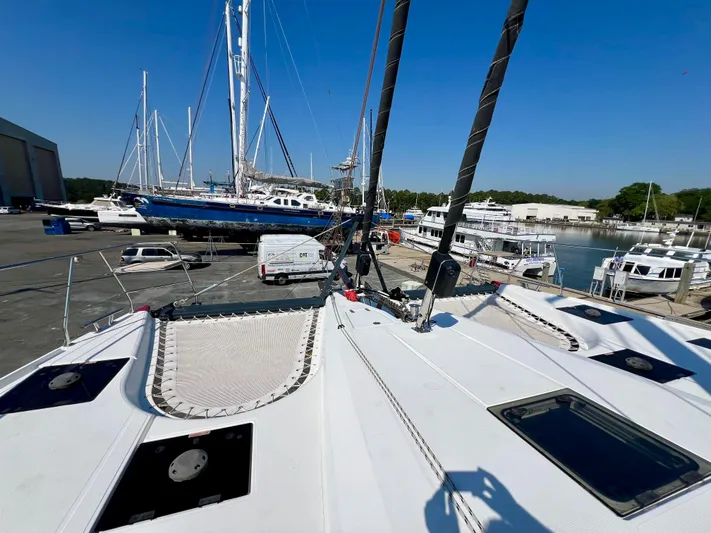 Rogue Yacht Photos Pics 2021 Privilege 510 catamaran docked at marina, surrounded by other boats and clear blue sky.