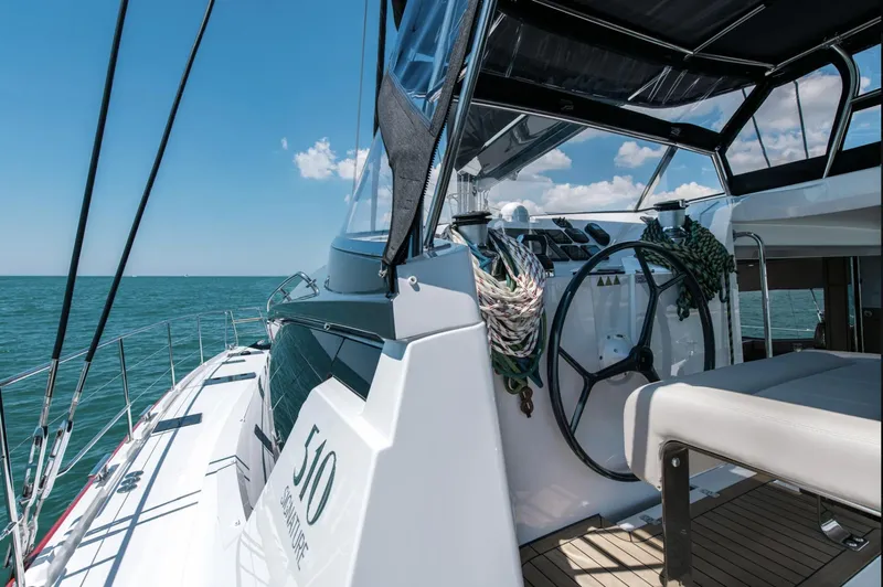 Rogue Yacht Photos Pics Luxury Privilege 510 yacht deck with steering wheel, ocean view, and clear blue sky.