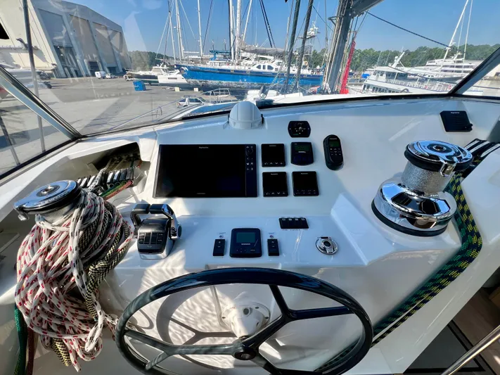 Rogue Yacht Photos Pics Helm of 2021 Privilege 510 yacht with navigation controls and ropes in a marina setting.
