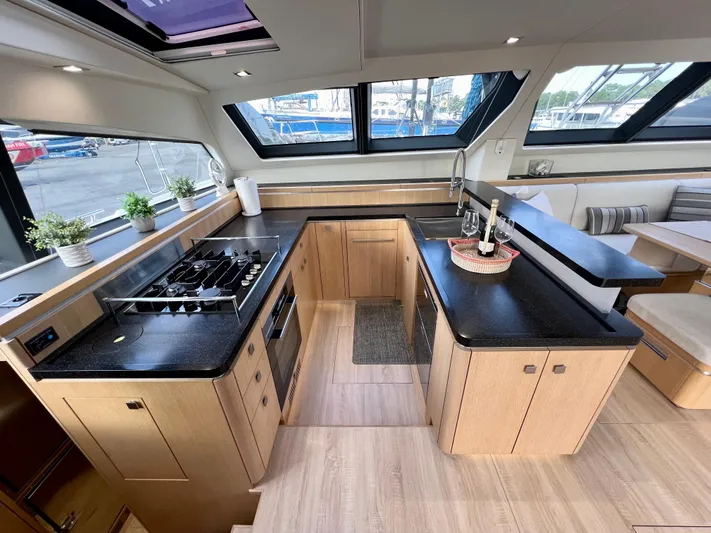 Rogue Yacht Photos Pics Luxurious Privilege 510 yacht kitchen with modern appliances and elegant wood cabinetry, 2021 model.