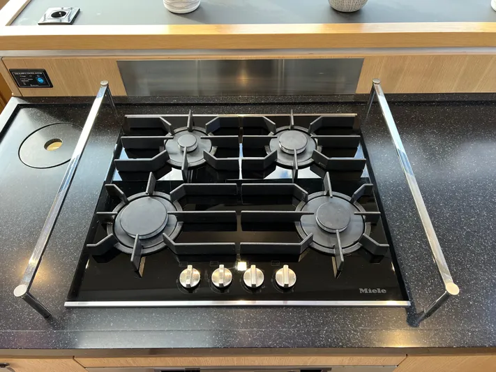Rogue Yacht Photos Pics Four-burner Miele gas stove on Privilege 510 yacht, 2021 model, with sleek black countertop.