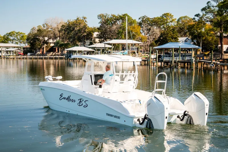 Endless Bs Yacht Photos Pics 2023 Twin Vee 260 GFX CC boat cruising on a calm lake with scenic background.