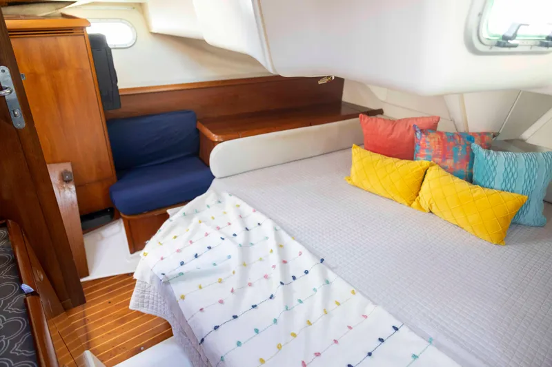 Atlas Yacht Photos Pics Cozy cabin interior of 2001 Jeanneau Sun Odyssey 43 DS with colorful pillows and wooden accents.