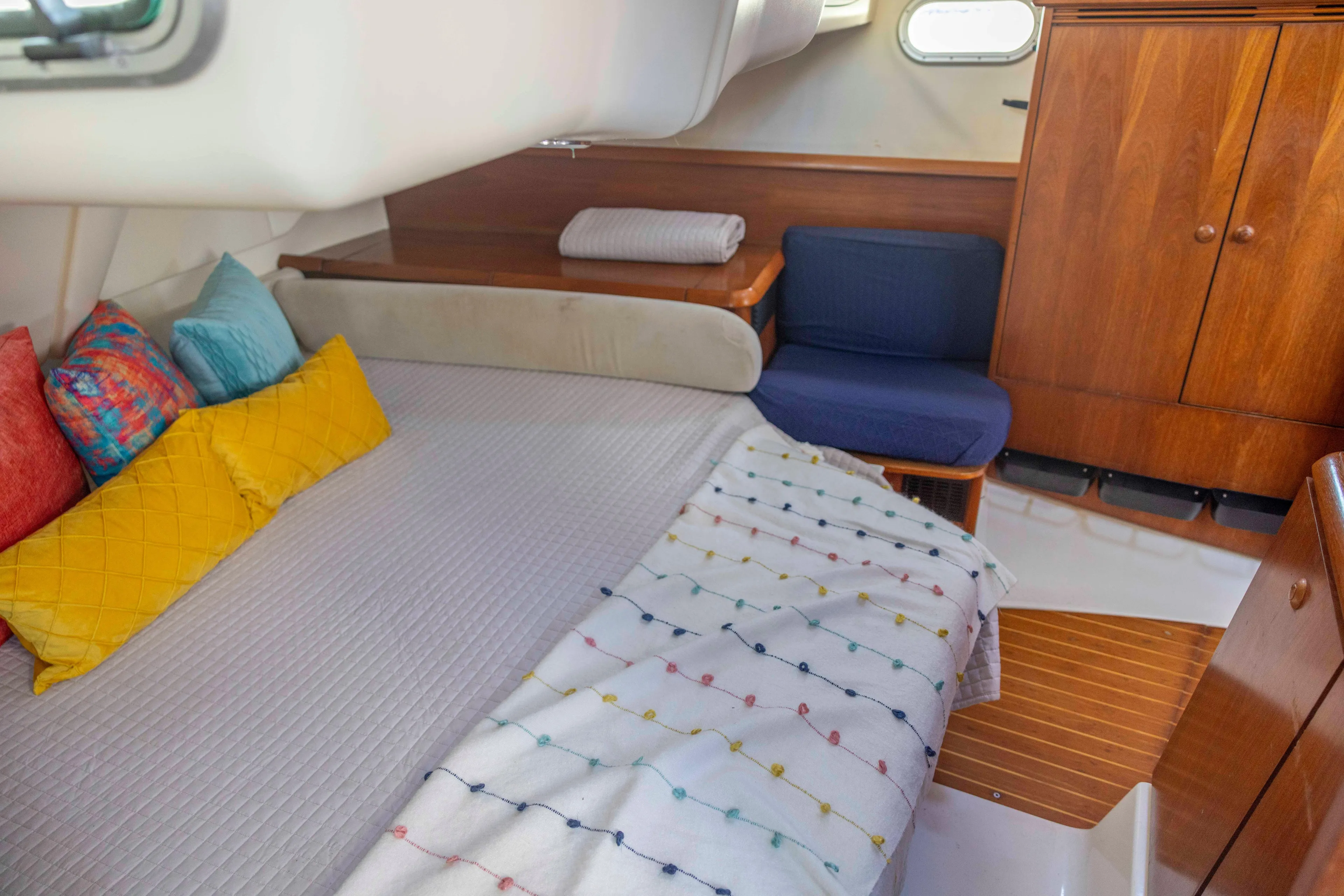 Atlas Yacht Photos Pics Cozy cabin interior of 2001 Jeanneau Sun Odyssey 43 DS with colorful pillows and wooden furnishings.