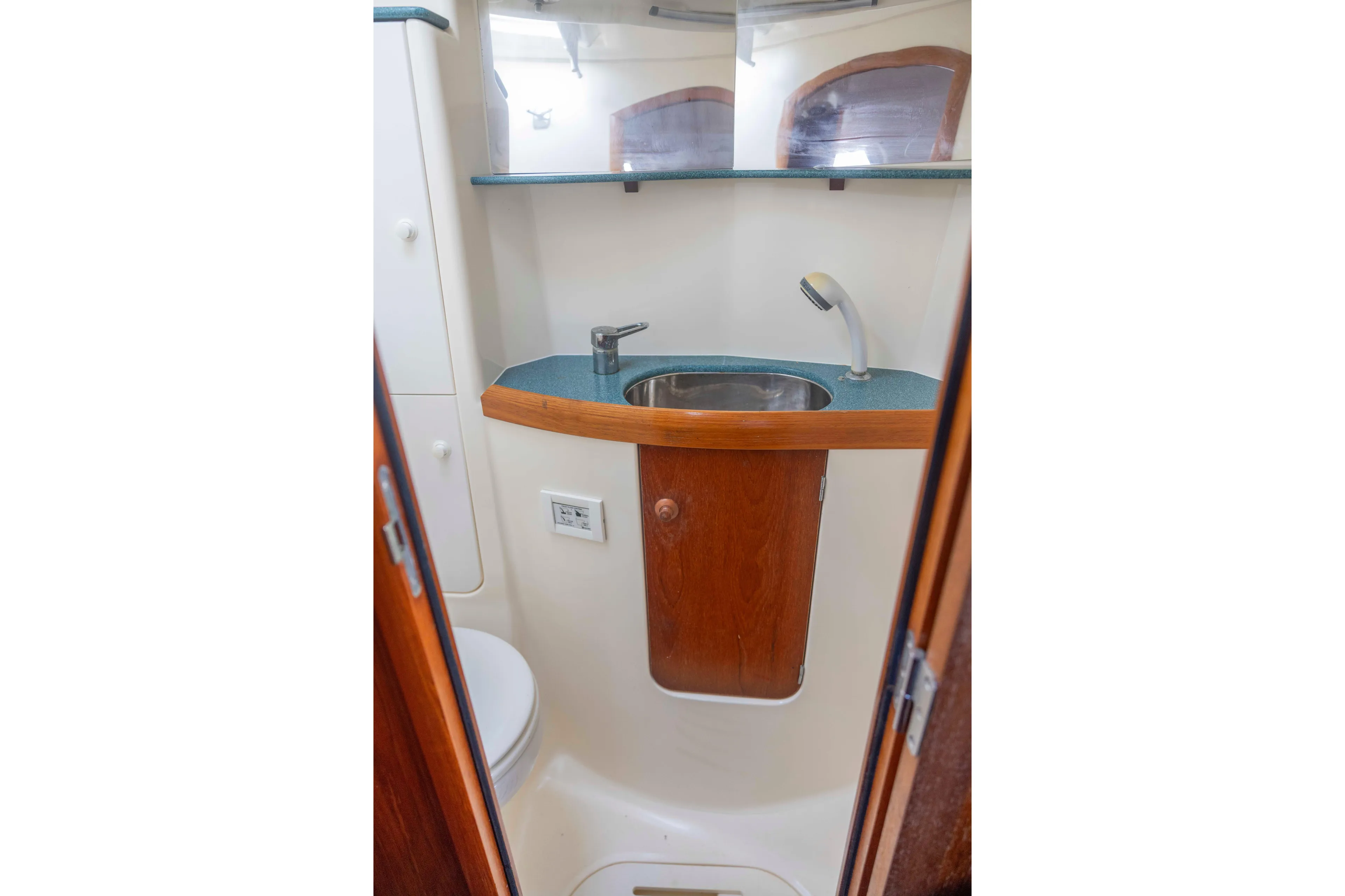 Atlas Yacht Photos Pics Bathroom interior of 2001 Jeanneau Sun Odyssey 43 DS yacht, featuring sink and wooden cabinetry.