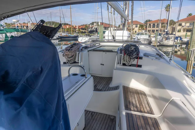 Atlas Yacht Photos Pics 2001 Jeanneau Sun Odyssey 43 DS sailboat cockpit with marina view, featuring wooden seating and rigging.