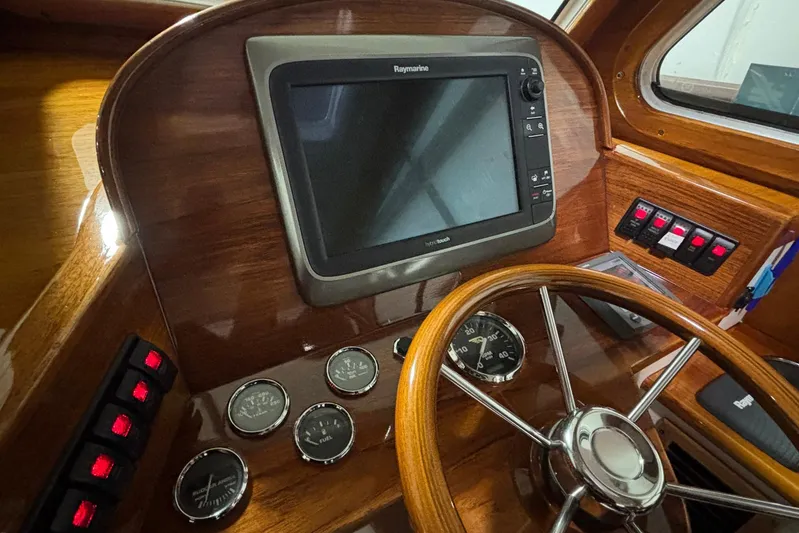 Manitou Yacht Photos Pics Helm of 2004 Hinckley 36 Picnic Boat EP with Raymarine display and wooden steering wheel.
