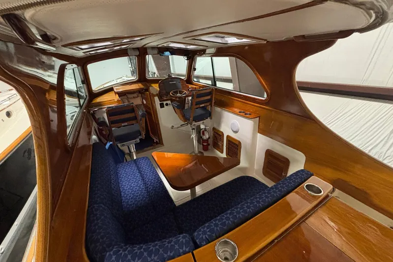 Manitou Yacht Photos Pics Interior of 2004 Hinckley 36 Picnic Boat EP with elegant wood finish and blue seating.