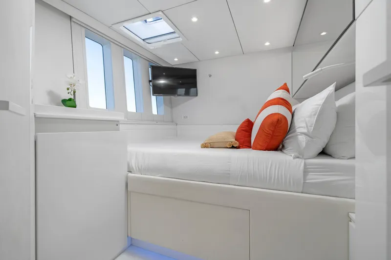Royal Rita Yacht Photos Pics Luxurious Sunreef 70 yacht bedroom, modern design, 2016 model, with TV and vibrant pillows.