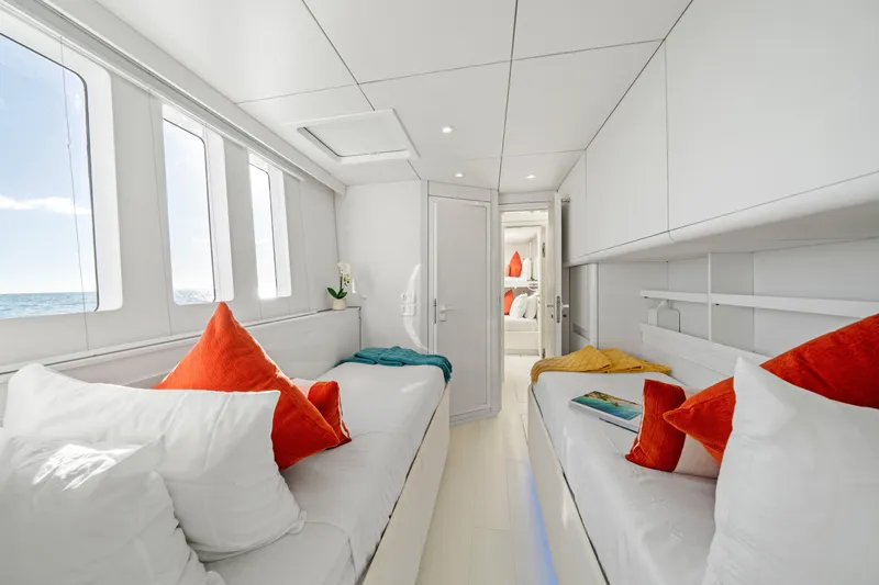 Royal Rita Yacht Photos Pics Luxurious Sunreef 70 yacht interior, 2016 model, featuring cozy beds and vibrant decor.