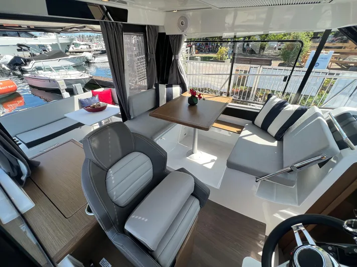  Yacht Photos Pics Modern interior of 2021 Jeanneau 895 boat with seating and dining area.