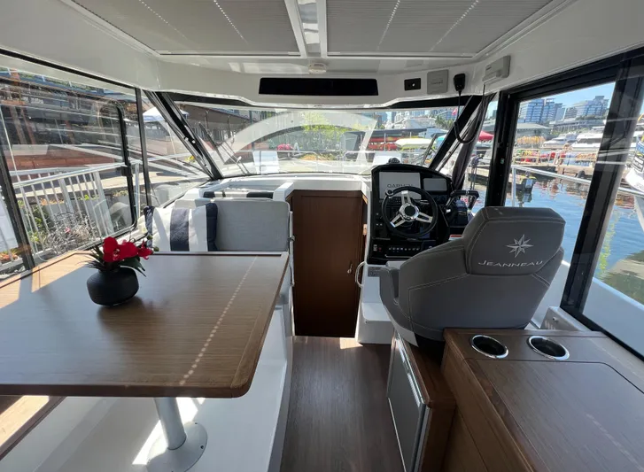  Yacht Photos Pics Interior of 2021 Jeanneau 895 boat with helm, seating, and table.