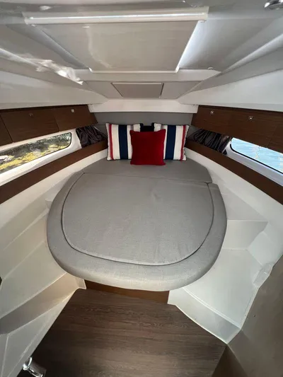  Yacht Photos Pics 2021 Jeanneau 895 cabin interior with bed and decorative pillows.