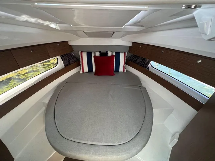  Yacht Photos Pics Cozy cabin interior of 2021 Jeanneau 895 with modern bedding and wood accents.