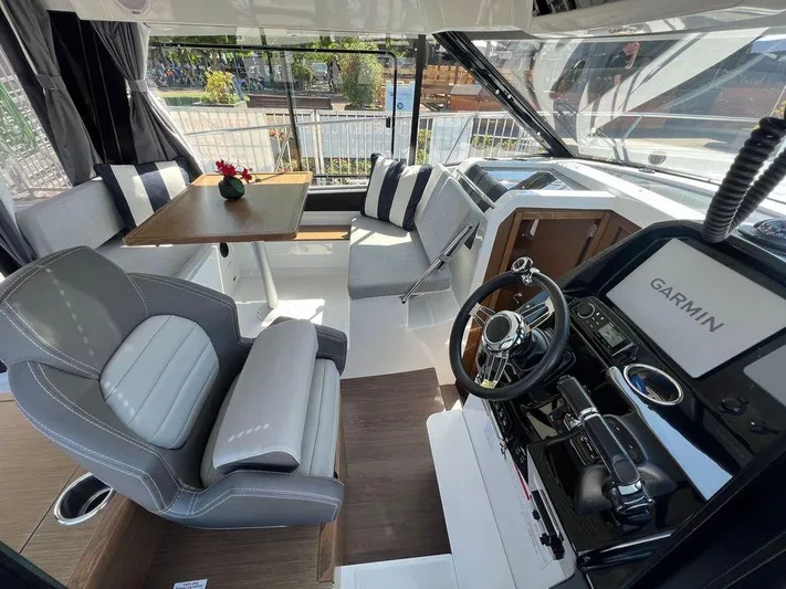  Yacht Photos Pics Interior of 2021 Jeanneau 895 boat with modern helm, seating, and dining area.