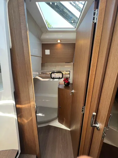 Yacht Photos Pics Interior of 2021 Jeanneau 895 boat with wooden finish and skylight.