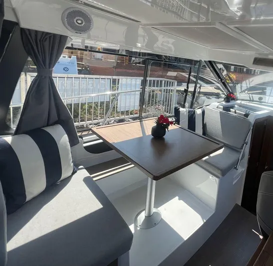  Yacht Photos Pics Interior of 2021 Jeanneau 895 boat with dining area and striped cushions.