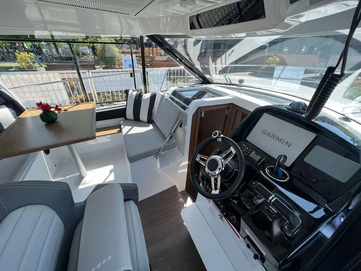  Yacht Photos Pics 2021 Jeanneau 895 boat interior with Garmin navigation system and seating area.