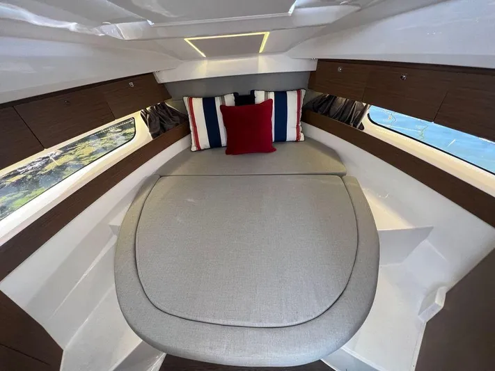  Yacht Photos Pics 2021 Jeanneau 895 cabin interior with bed, pillows, and side windows.